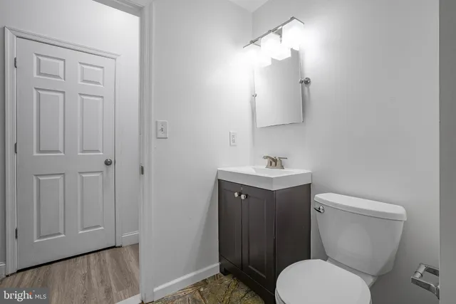 a bathroom with a toilet sink vanity and mirror