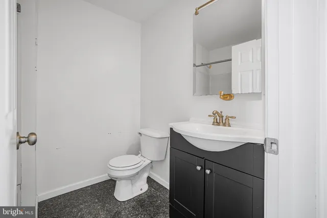 a bathroom with a sink toilet and a mirror