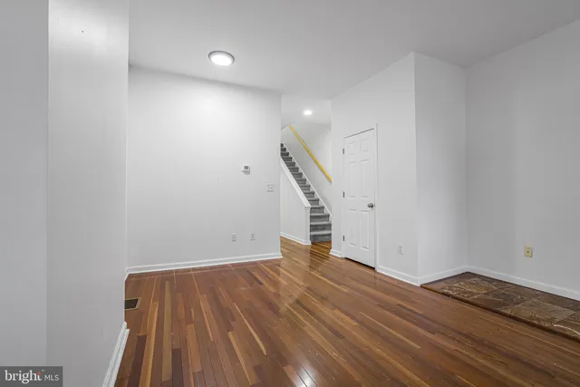 a view of an empty room with wooden floor