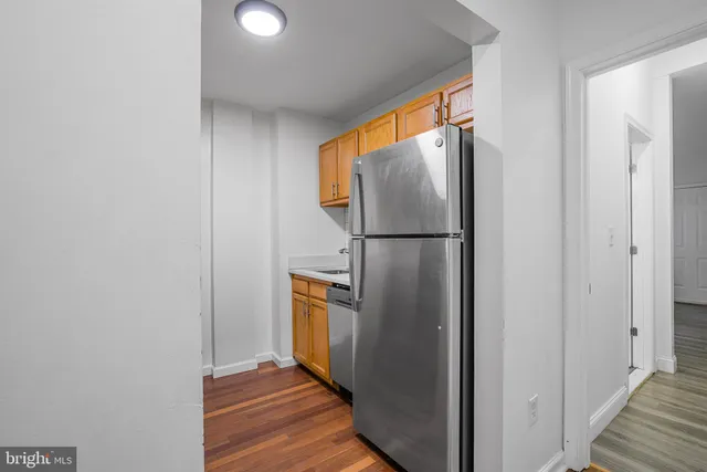 a view of a hallway with wooden floor and glass door