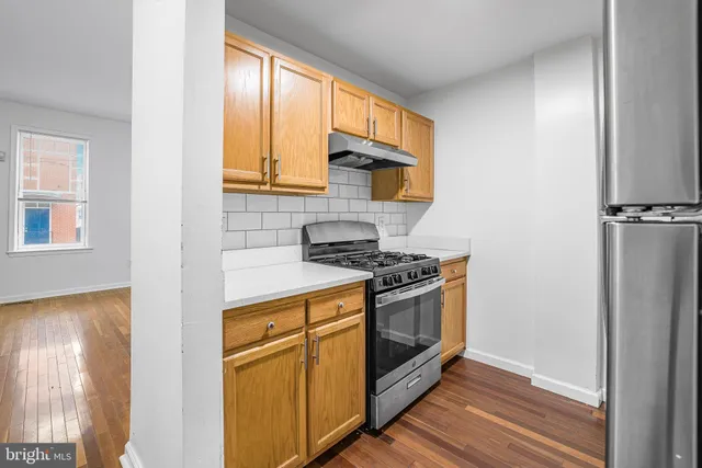 a kitchen with stainless steel appliances granite countertop a stove and a refrigerator