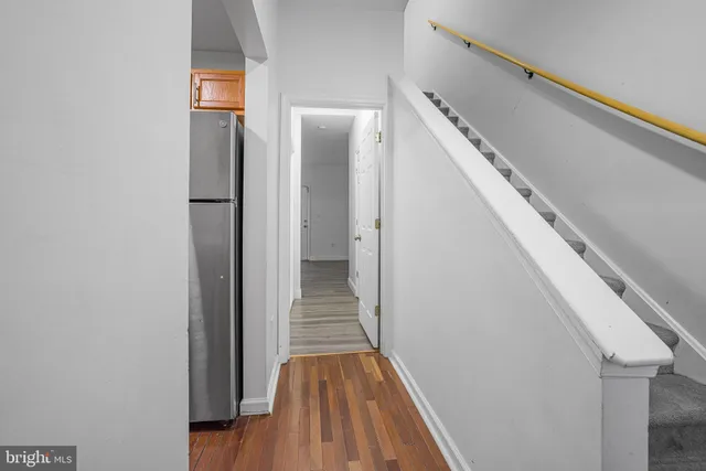 a view of a hallway with wooden floor and staircase