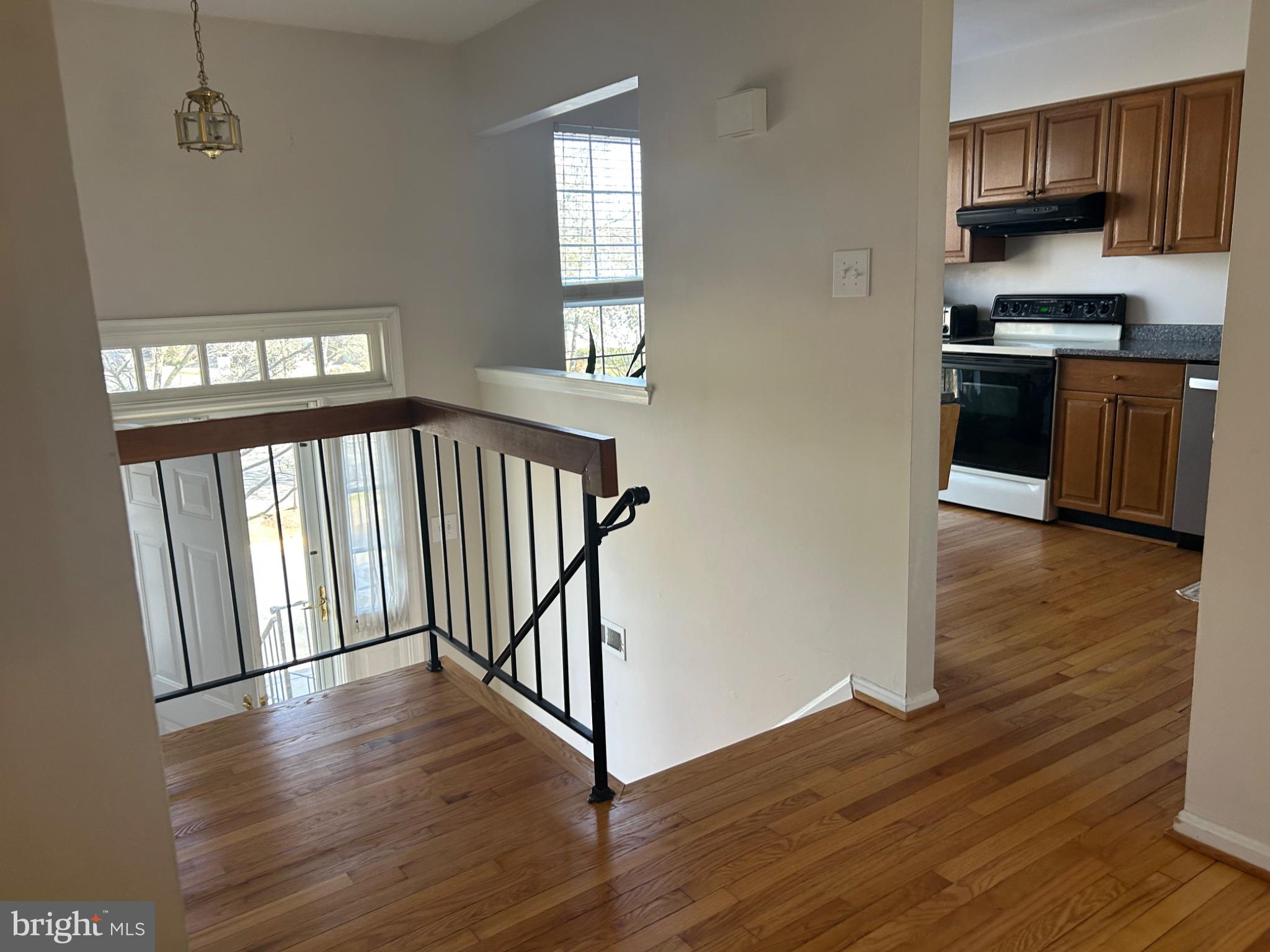 5833 Pin Oak Commons Court Burke, VA 22015 - Photo 2 of 15 a view of a kitchen with stainless steel appliances wooden floor and a window