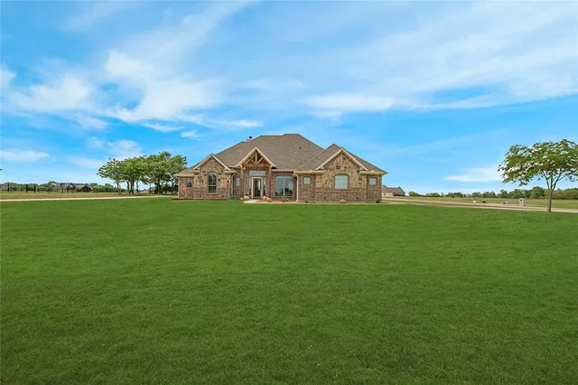 a view of a green field with wooden fence