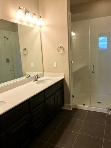 a bathroom with a double vanity sink mirror and shower