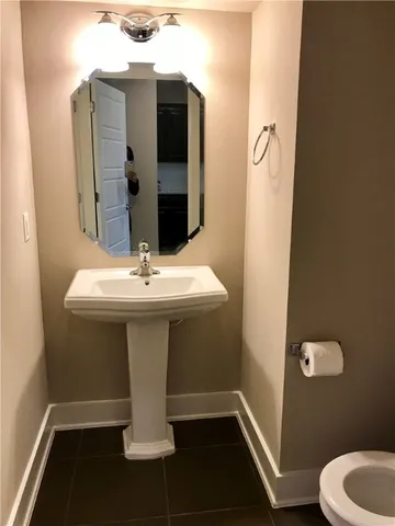 a bathroom with a sink toilet and mirror
