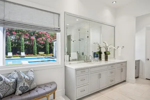a spacious bathroom with a granite countertop sink mirror and bathtub