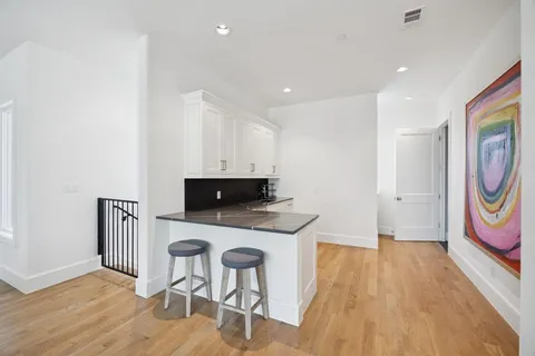 a kitchen with wooden floor and cabinets