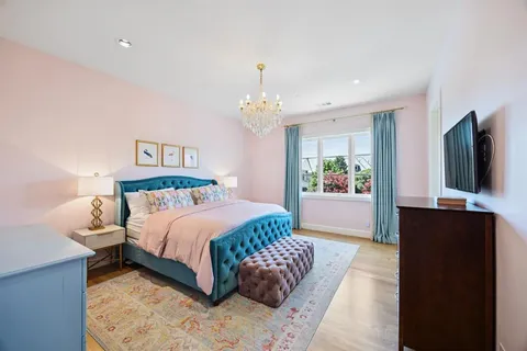 a bedroom with a bed mirror and window