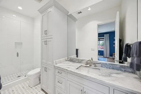 a bathroom with a sink a toilet and a large mirror