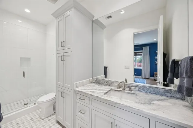 a bathroom with a sink a toilet and a large mirror