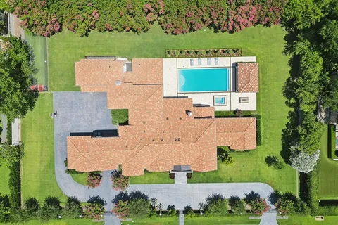 an aerial view of a house with a garden and trees