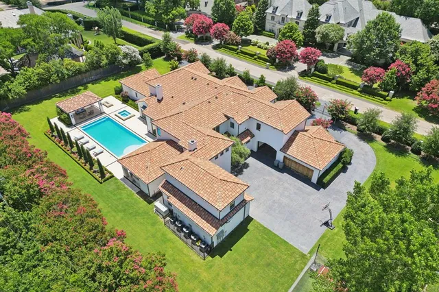 an aerial view of a house with a garden and lake view