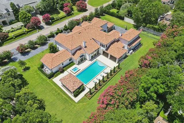 an aerial view of a house with swimming pool a patio and yard