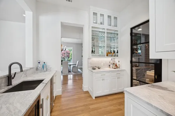 a large kitchen with stainless steel appliances kitchen island granite countertop a stove a sink a refrigerator and a dining table with wooden floor
