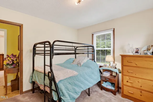 a bedroom with a bed and large windows