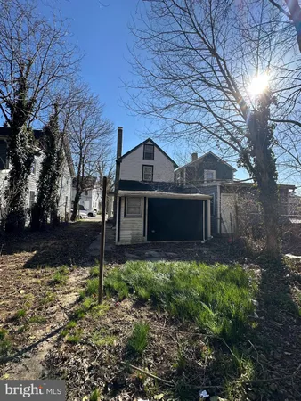 a front view of a house with a yard and tree