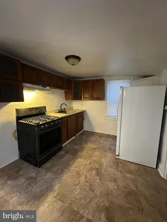 a view of kitchen with a sink and a refrigerator