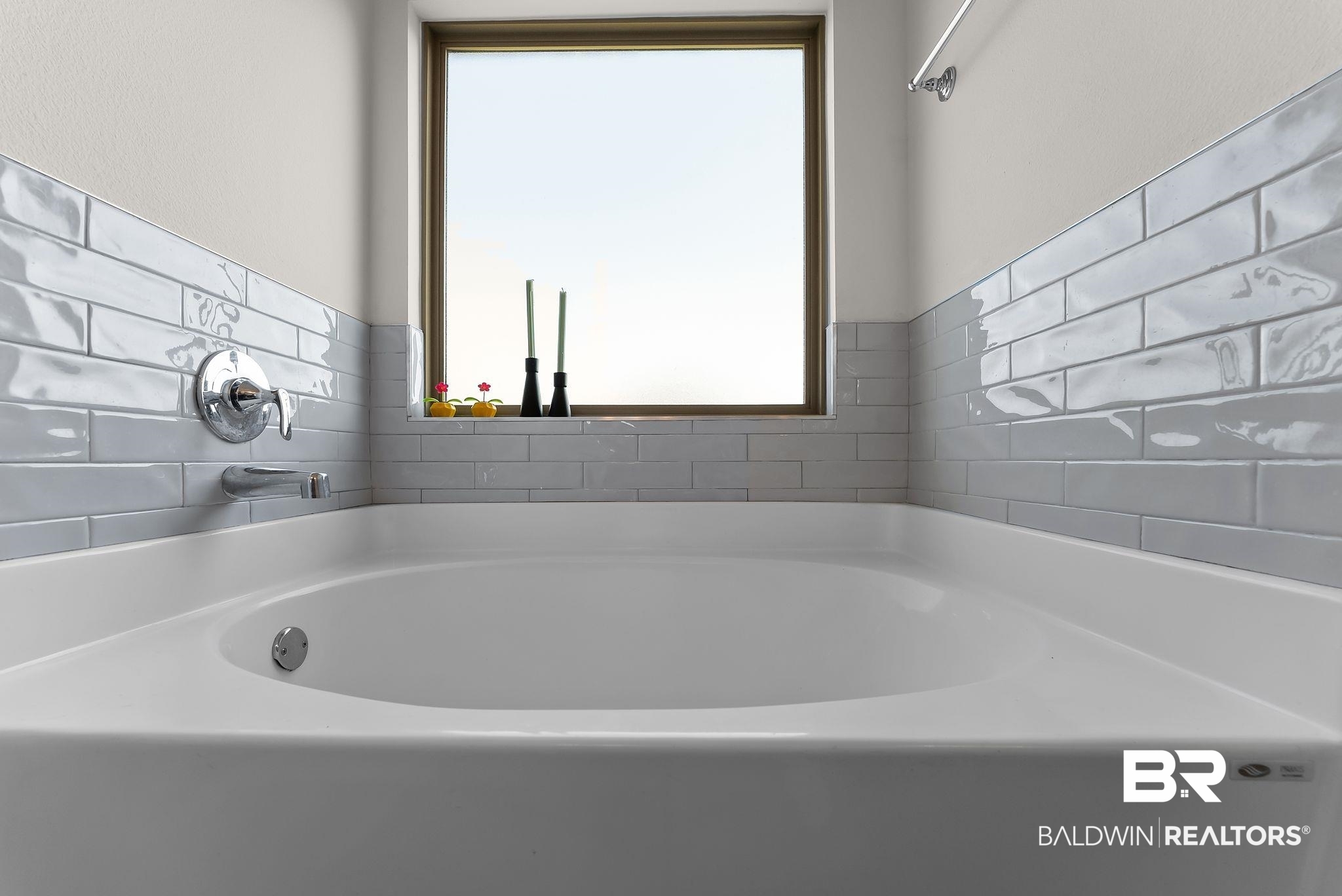 16607 Prado Loop Loxley, AL 36551 - Photo 35 of 46 Built-in soaking tub featuring chrome fixtures, light gray subway tile surround, and a rectangular window
