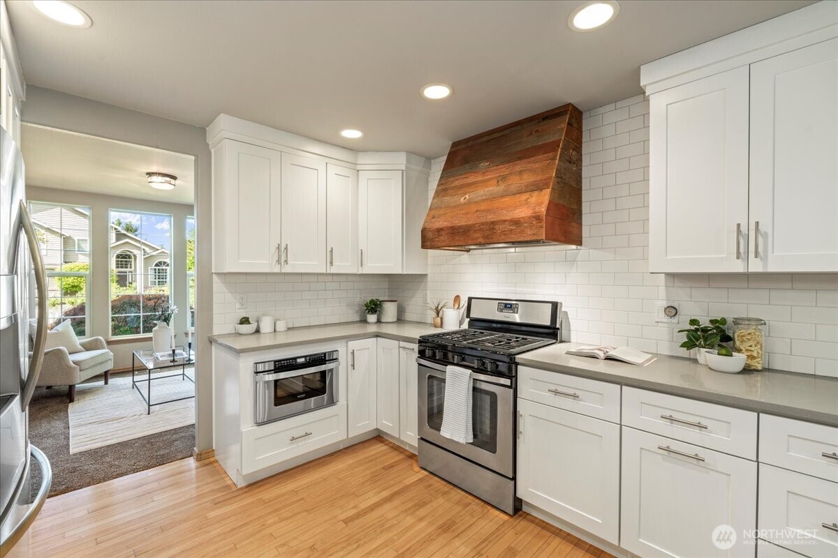 1218 231st Street Southeast Bothell, WA 98021 - Photo 7 of 40 a kitchen with granite countertop cabinets stainless steel appliances and wooden floor