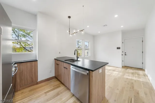 a kitchen with stainless steel appliances granite countertop a sink a stove and a refrigerator