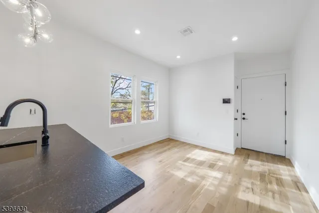 a view of kitchen and hall with wooden floor
