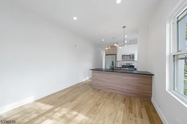 a large kitchen with kitchen island a sink stainless steel appliances and cabinets
