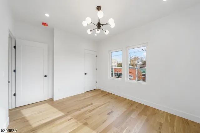 a view of empty room with wooden floor and ceiling fan
