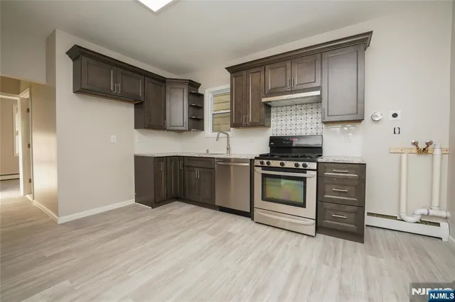a kitchen with granite countertop wooden cabinets and stainless steel appliances