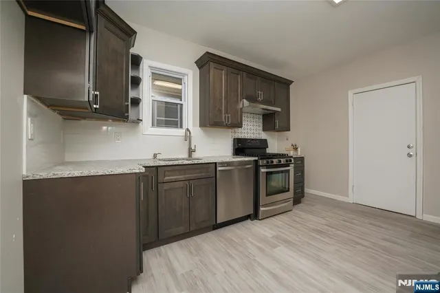 a kitchen with stainless steel appliances granite countertop a stove and a sink