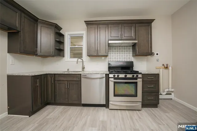 a kitchen with stainless steel appliances wooden cabinets and a stove top oven