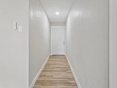 a view of a hallway with wooden floor