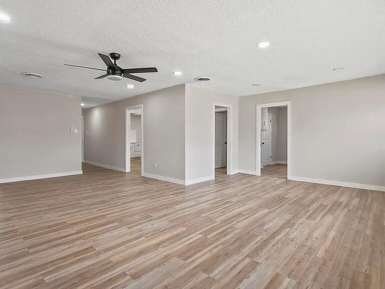 4308 43rd Street Lubbock, TX 79413 - Photo 3 of 18 a view of an empty room with wooden floor and a ceiling fan