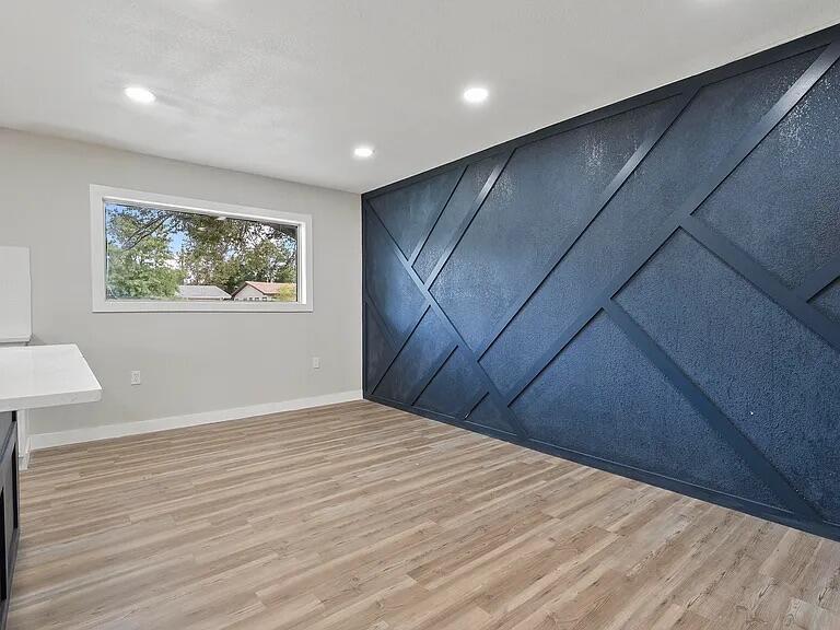 4308 43rd Street Lubbock, TX 79413 - Photo 8 of 18 a view of an empty room with wooden floor and a window