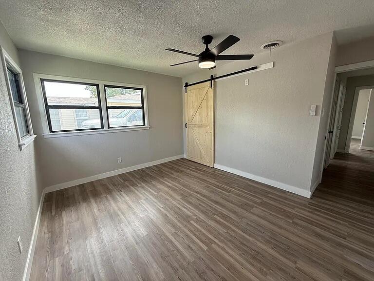 4308 43rd Street Lubbock, TX 79413 - Photo 10 of 18 a view of empty room with wooden floor and fan
