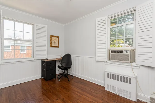 a view of a workspace with furniture and a window