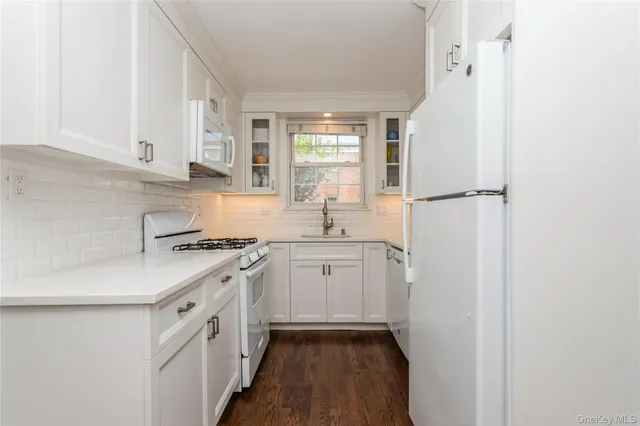 a kitchen with white cabinets and white appliances