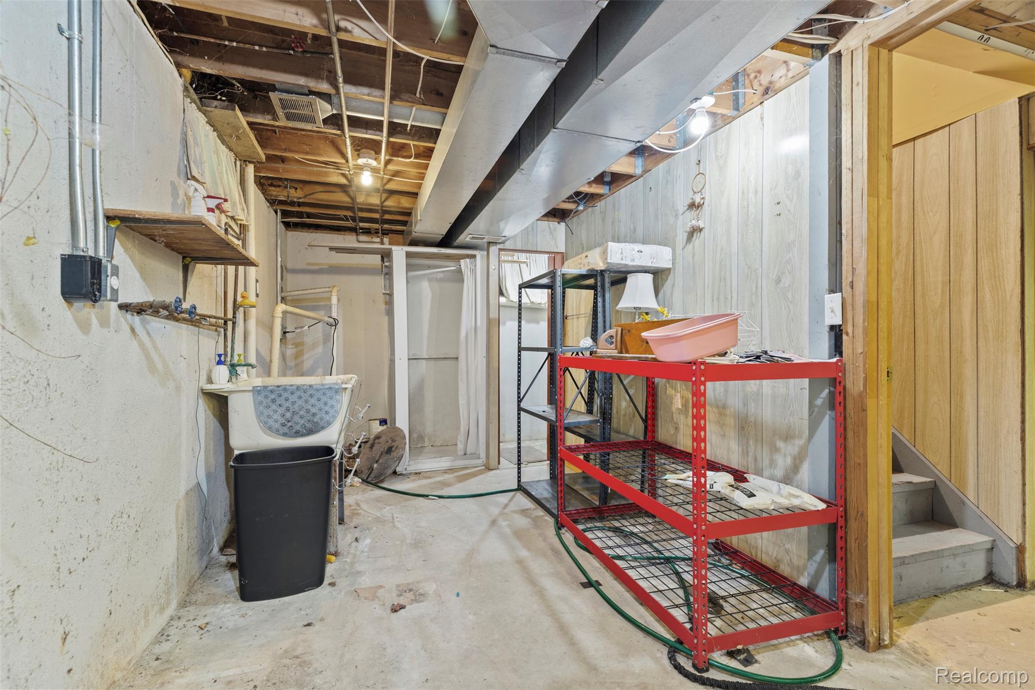 309 Windy Bluff Street Flushing, MI 48433 - Photo 26 of 32 Utility space featuring a laundry sink, exposed ceiling joists, and concrete flooring