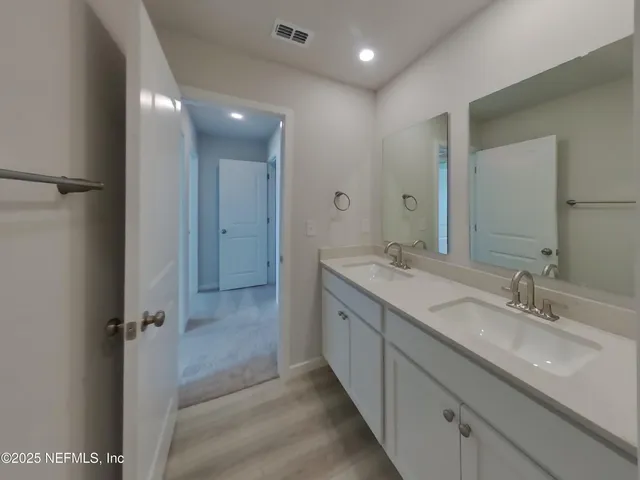 a bathroom with a double vanity sink and mirror