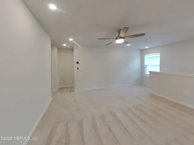 an empty room with fan and windows