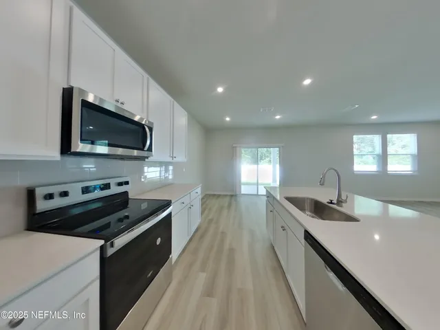 a kitchen with stainless steel appliances a stove sink microwave and cabinets