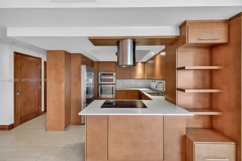a kitchen with stainless steel appliances granite countertop a refrigerator and a stove top oven
