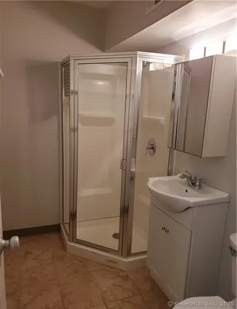 a bathroom with a shower sink and mirror