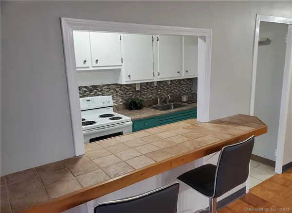 a room with a wooden floor and white cabinets