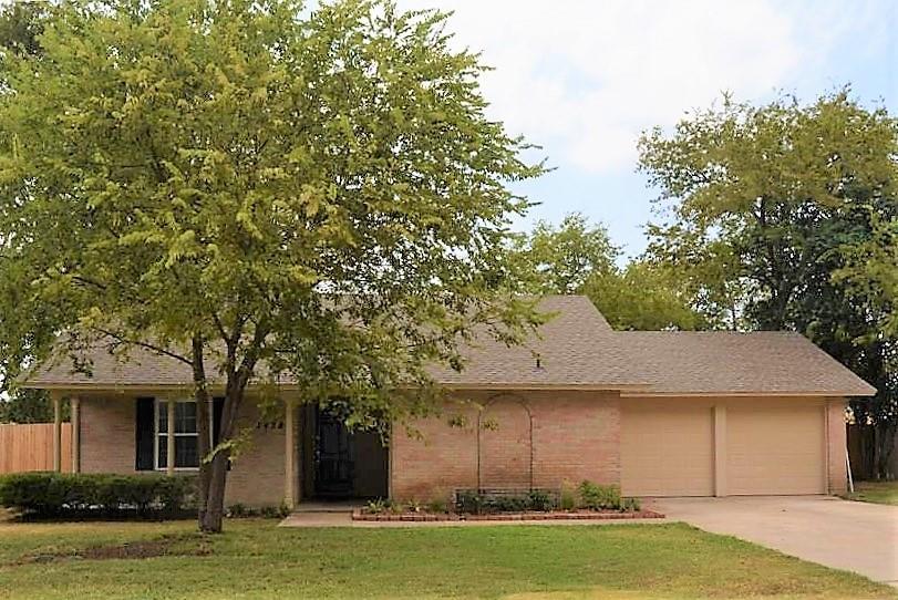 a front view of a house with a garden and trees