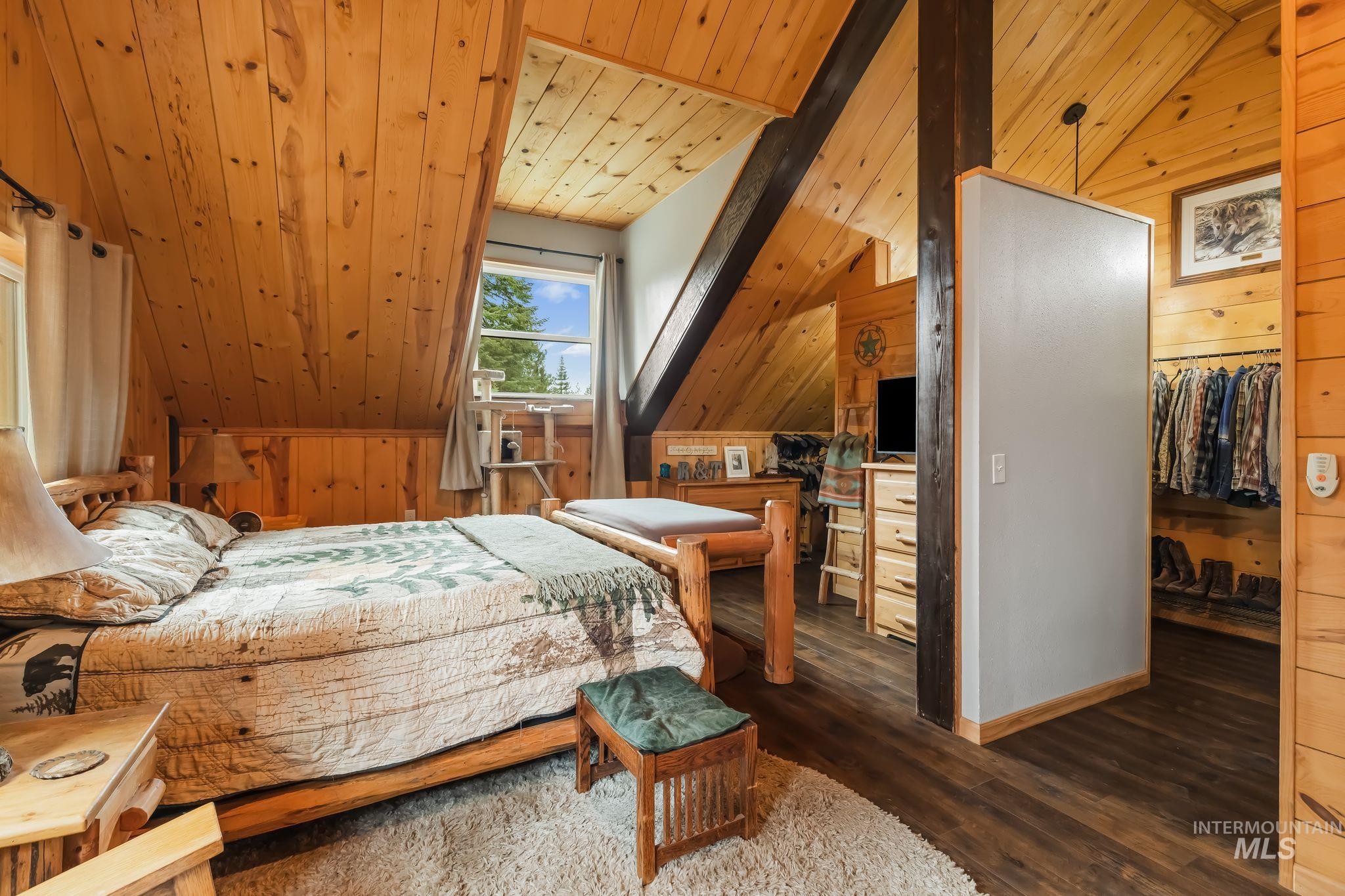 3989 East Mountain Road Anatone, WA 99401 - Photo 18 of 49 Vaulted wood-paneled ceilings, prominent exposed beams, wood-finish flooring, and a built-in closet system