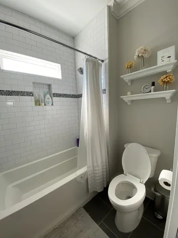 a bathroom with a toilet and a shower