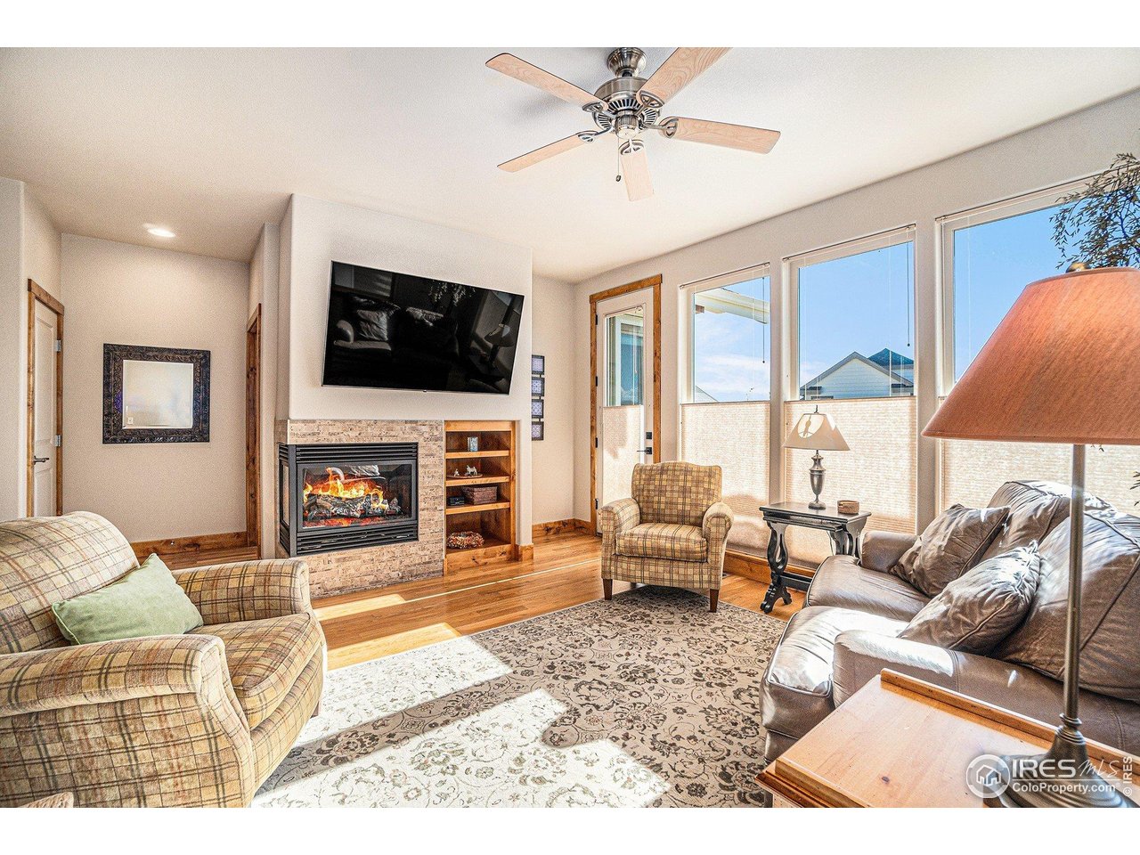 1827 Fromme Prairie Way Fort Collins, CO 80526 - Photo 2 of 21 a living room with furniture a flat screen tv and a fireplace