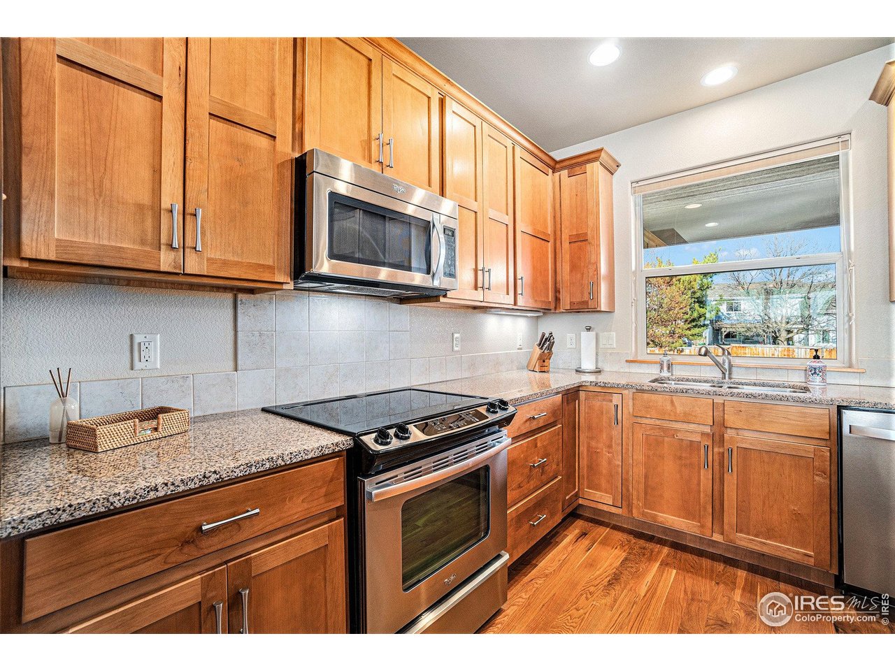 1827 Fromme Prairie Way Fort Collins, CO 80526 - Photo 8 of 21 a kitchen with stainless steel appliances granite countertop a stove a sink and a microwave