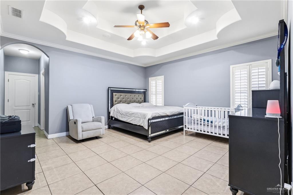 22602 Rio Rancho Road Harlingen, TX 78552 - Photo 13 of 26 a bedroom with a bed and a chandelier